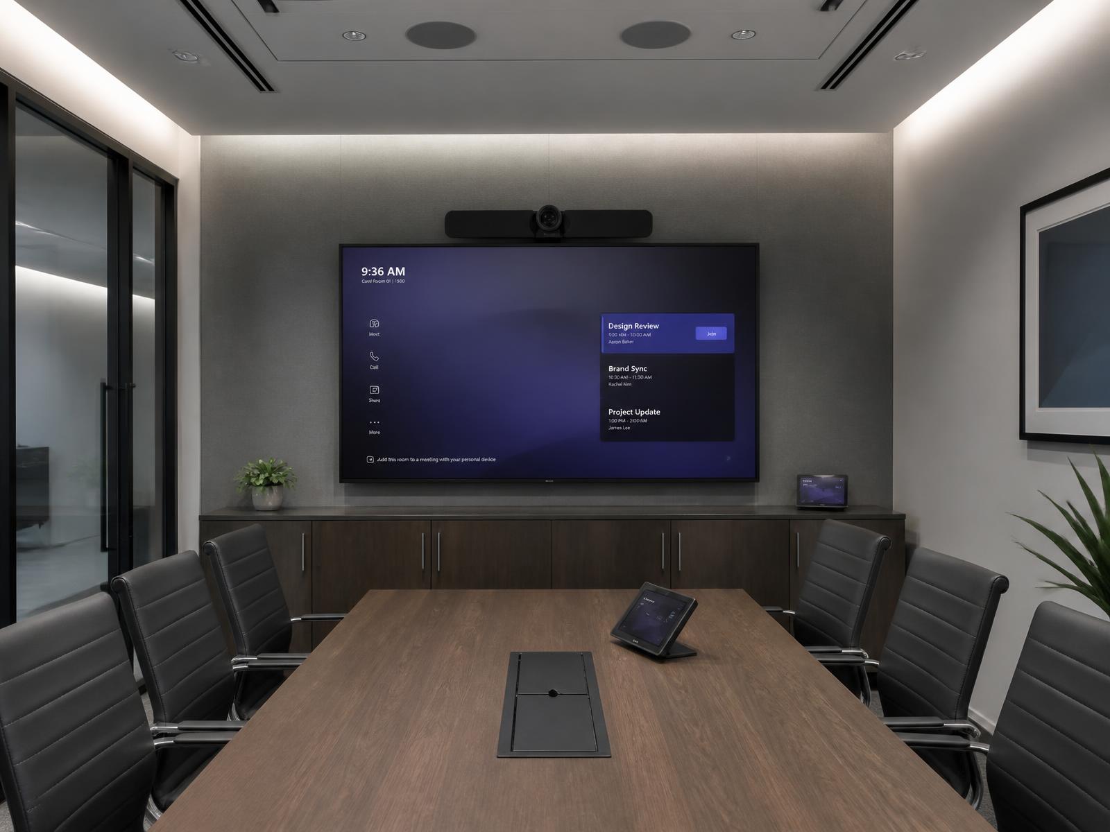Meeting room with a wall-mounted display and a video conferencing bar