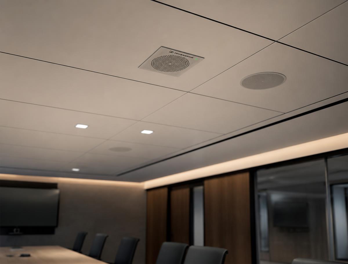 Ceiling microphone array and discreet ceiling speakers above a meeting room table